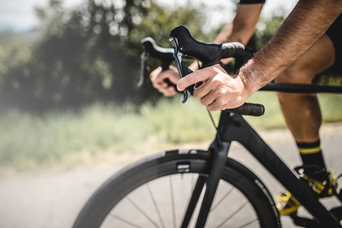 Ciclista che aziona la manetta del freno della sua bici.